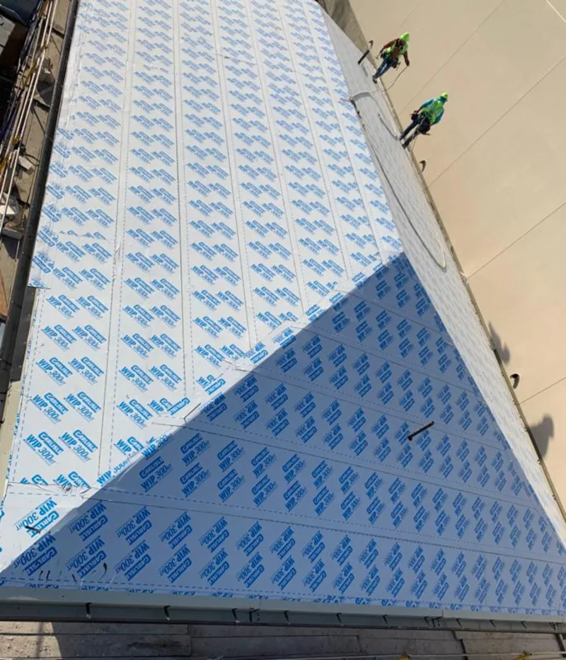 Professional roofers installing underlayment on a metal roof in Franklin Lakes